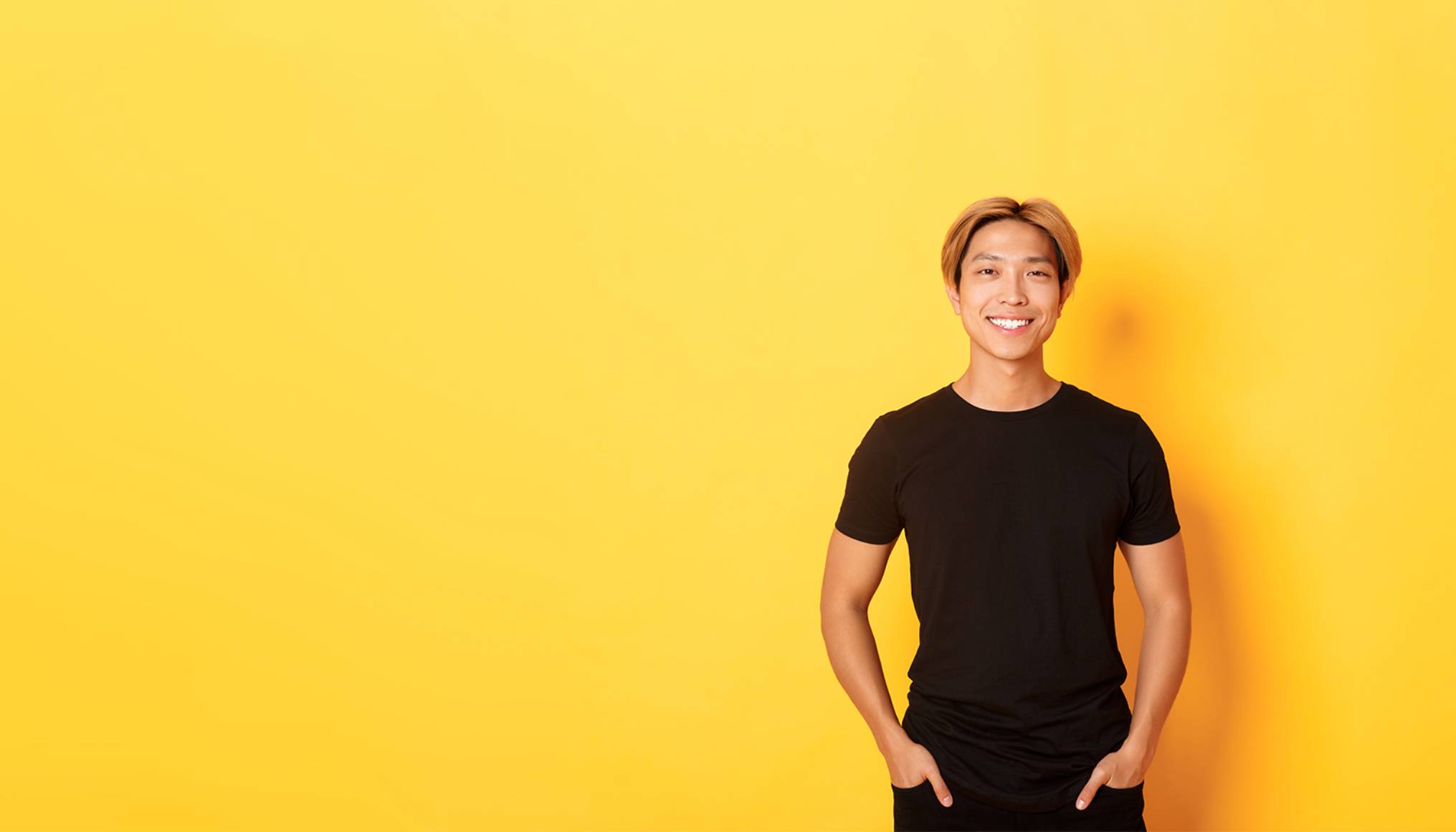 attractive smiling asian man black tshirt standing pleased yellow background copy